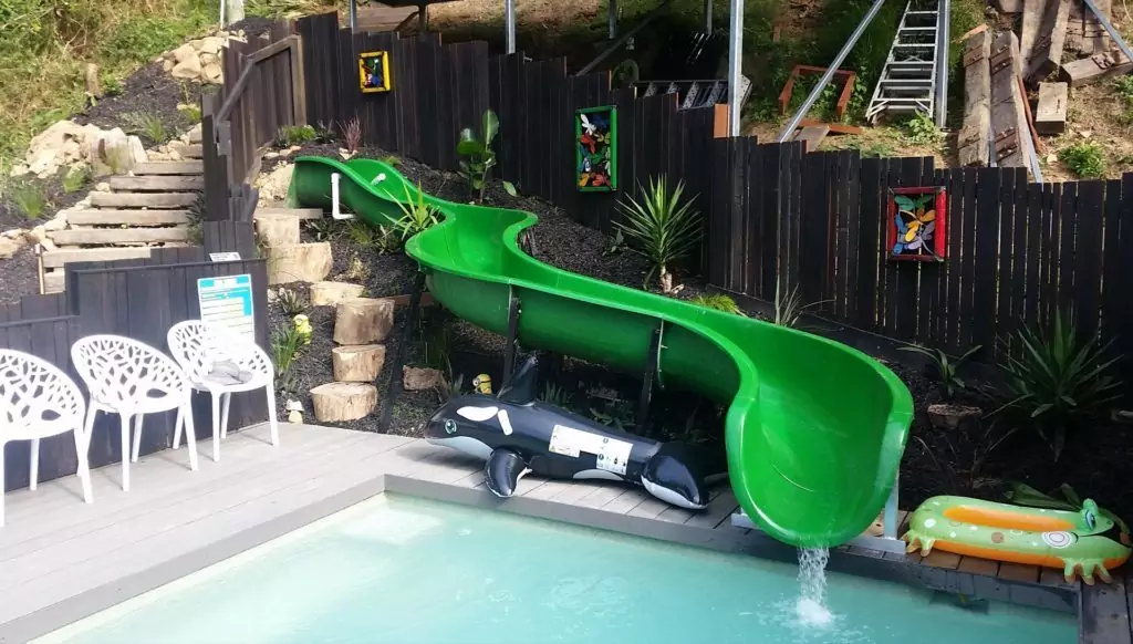 Genuine AquaSplash slide installed beside a landscaped pool